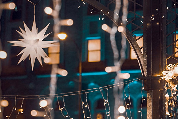 Holiday lights and a star hang in along an iron archway on the VCU campus