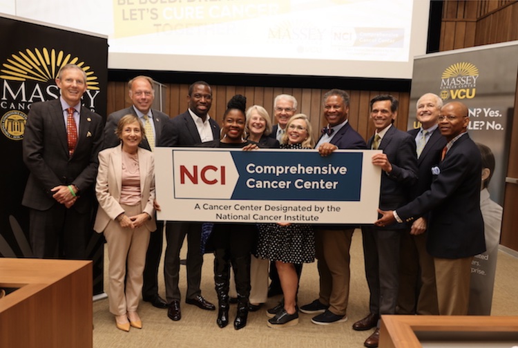 VCU Health team members and public officials standing together with a sign to celebrate the Massey Comprehensive designation 