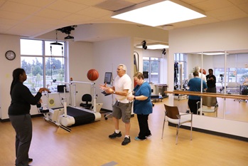 With the help of physical therapist Mary Beth O’Reilly, Corbin Cash plays catch with a physical therapy assistant while walking side-to-side.